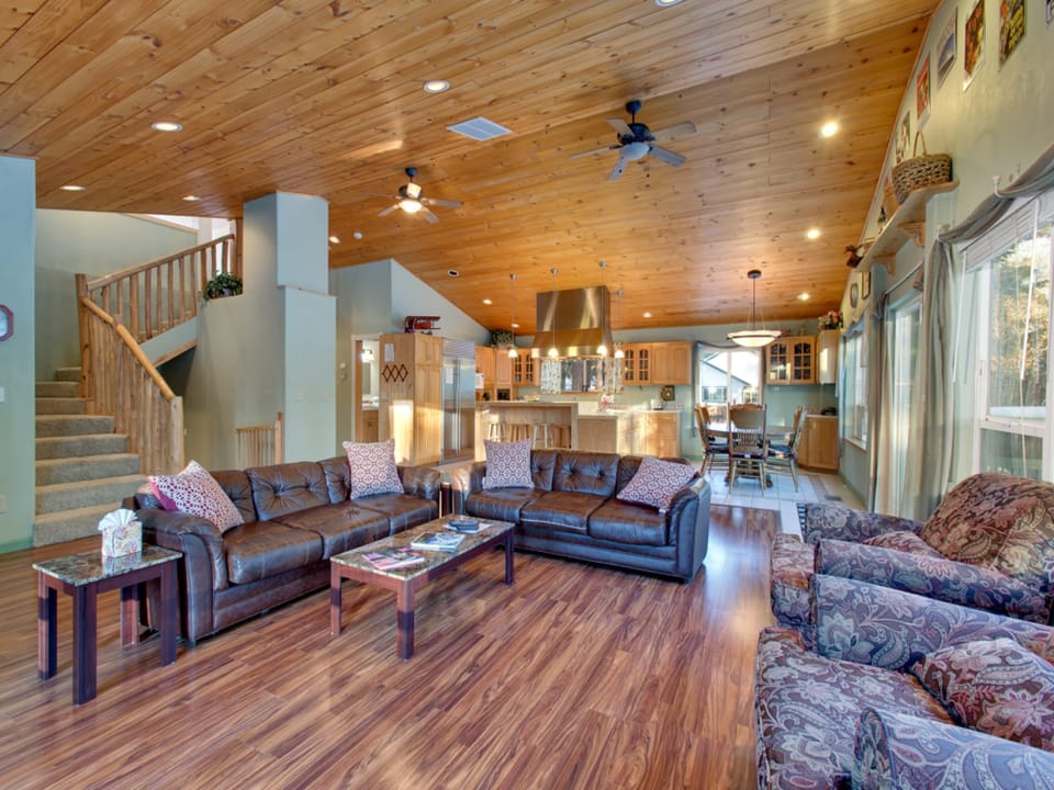 A second living area with high wood ceilings, comfortable seating, and an open, airy feel.