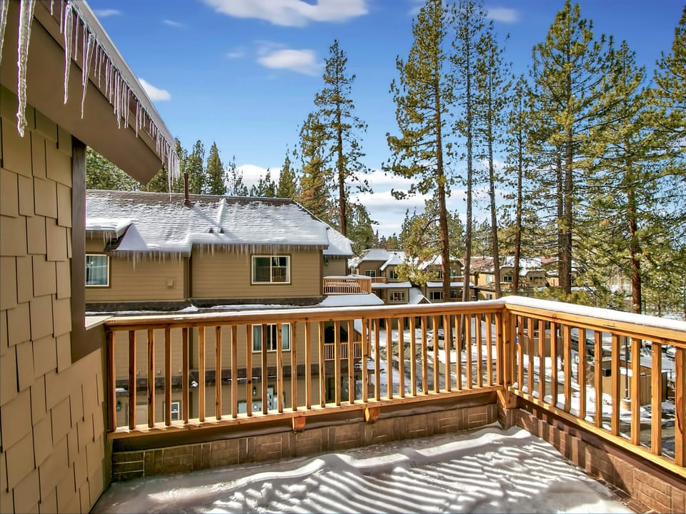Private balcony with wooden railings and a scenic forested backdrop