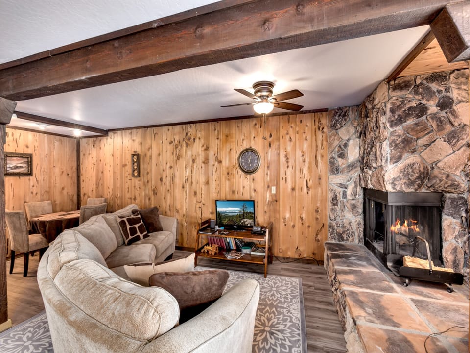 The living room’s warm stone fireplace adds to the chalet’s cozy ambiance.