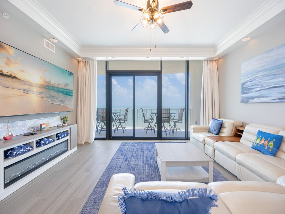 Relax in this spacious living area with entertainment, a fireplace, and coastal decor