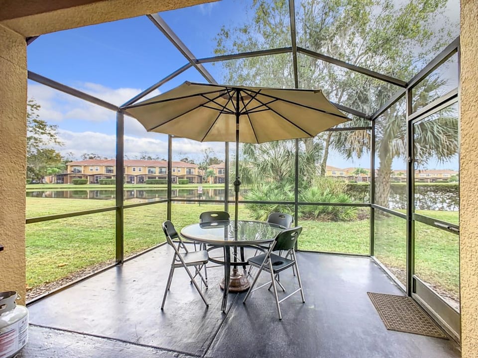 Scenic screened patio with outdoor seating and lush greenery views.