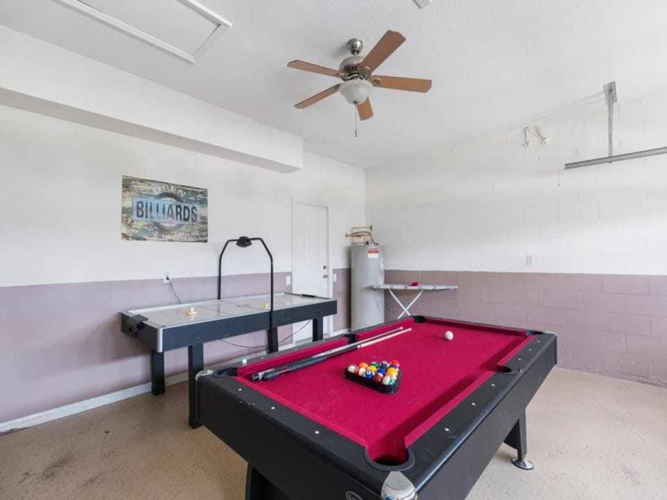 Game room with a sleek pool table and air hockey, perfect for family fun and competition.