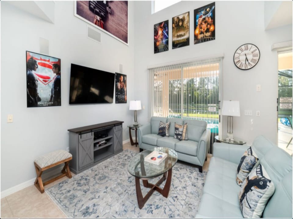 Elegant living room with a large TV, fireplace, and comfortable seating.