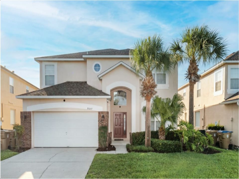 Elegant home with palm-lined entrance and plenty of curb appeal.