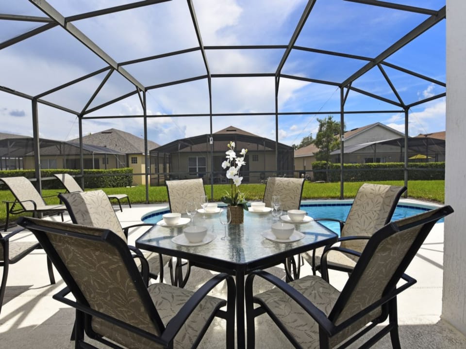 Enjoy outdoor dining with a spacious patio table by the pool.