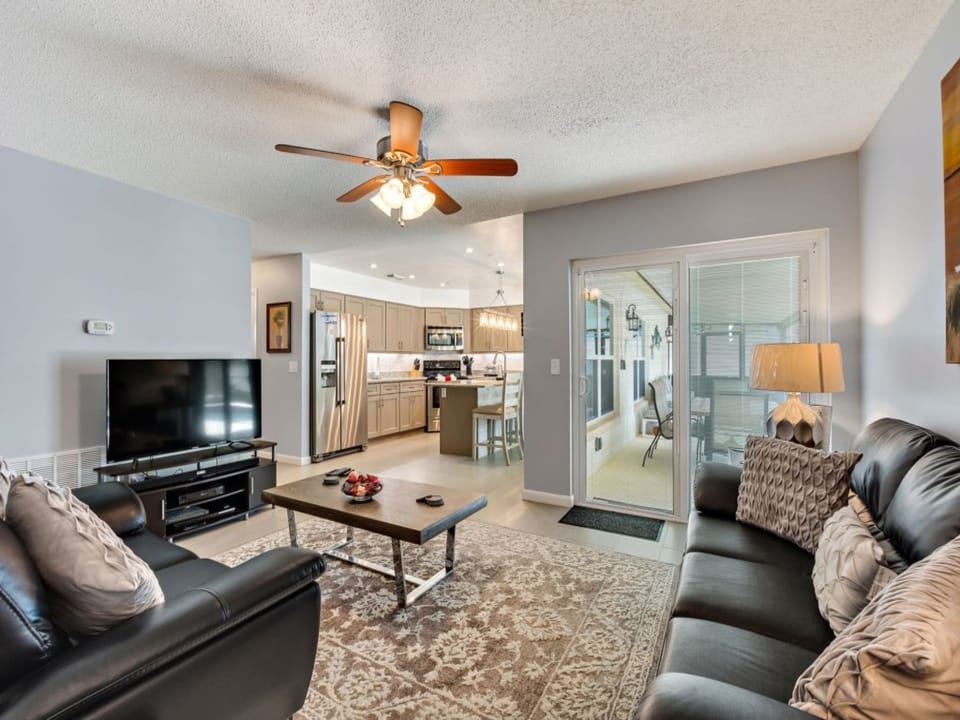 Cozy living room with plush seating and a view of the modern, open-concept kitchen.