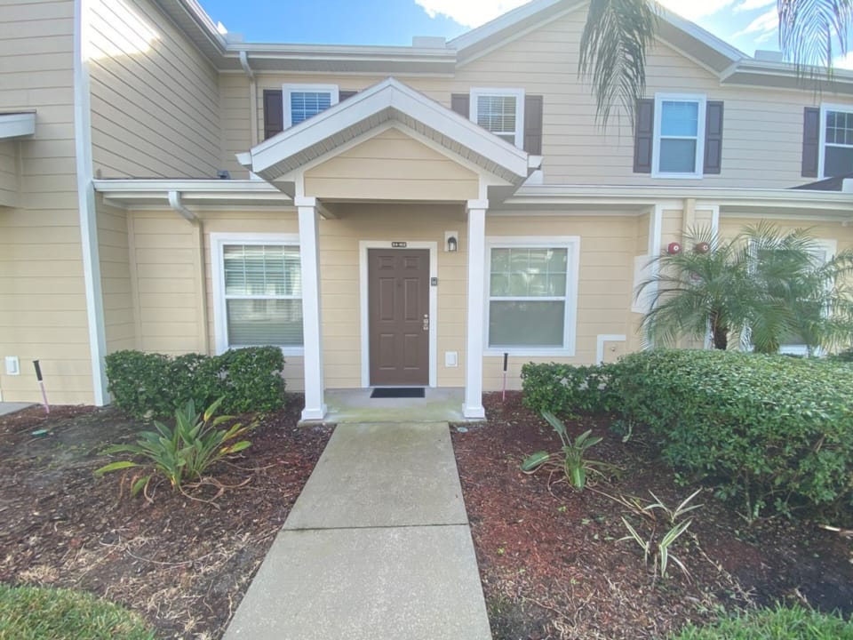 Cozy townhouse front with manicured landscaping and a private entrance.
