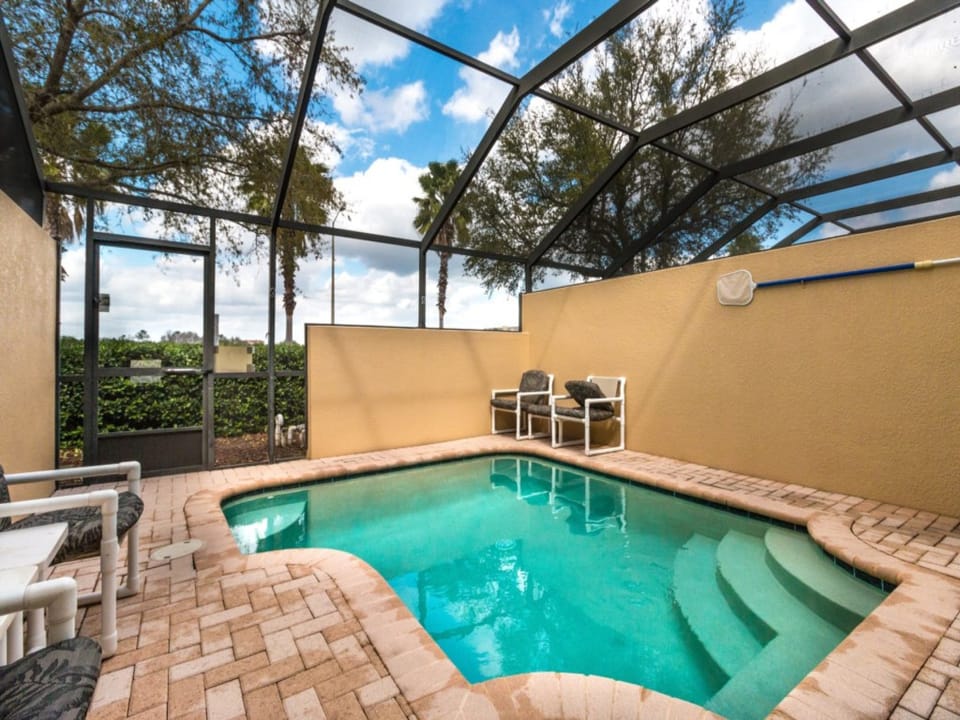 Private screened-in pool with patio seating – ideal for sunbathing or outdoor dining.