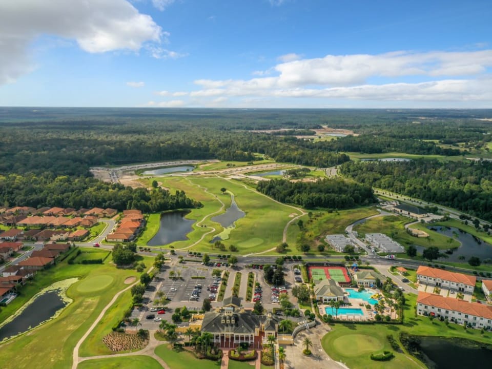 Bird's-eye view of the resort with pools, golf courses, and serene surroundings.