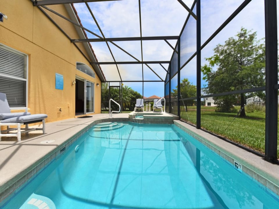 Spacious screened-in pool area with loungers for ultimate comfort.