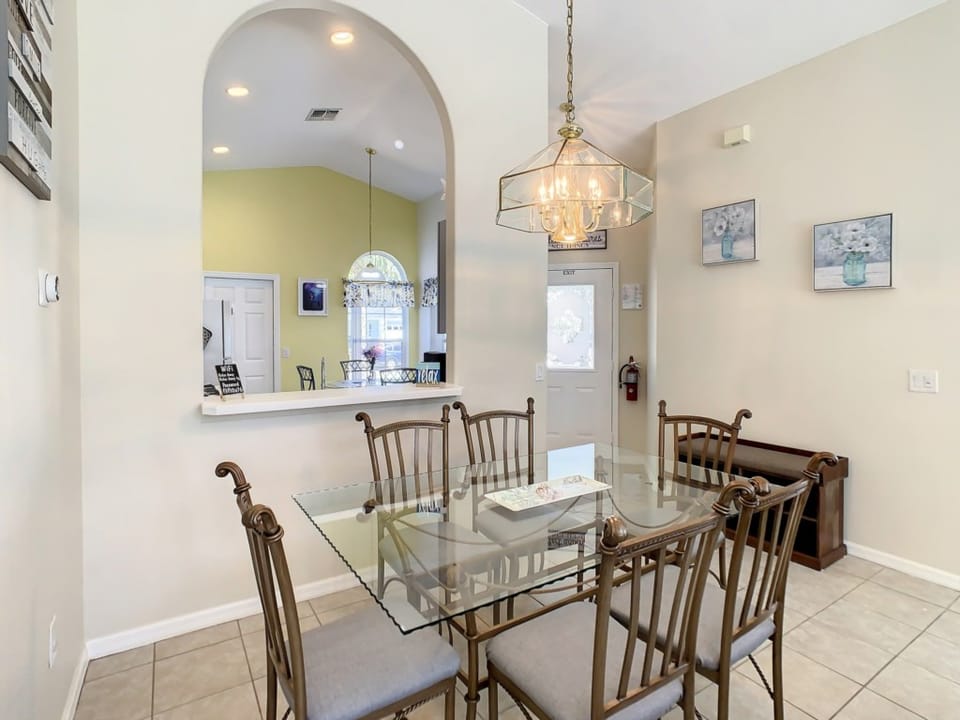 Dining area with a chic table setting and open kitchen access.