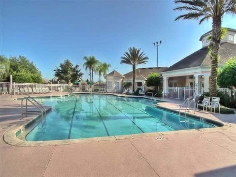 Sparkling community pool surrounded by palm trees and plenty of seating.