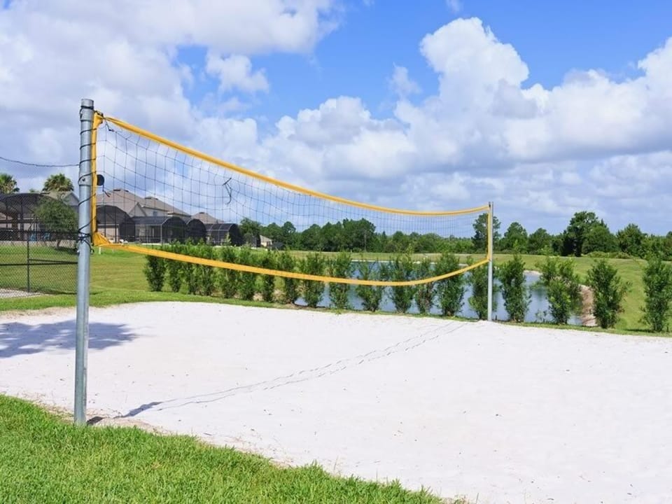 Sand volleyball court overlooking a scenic pond for outdoor fun.