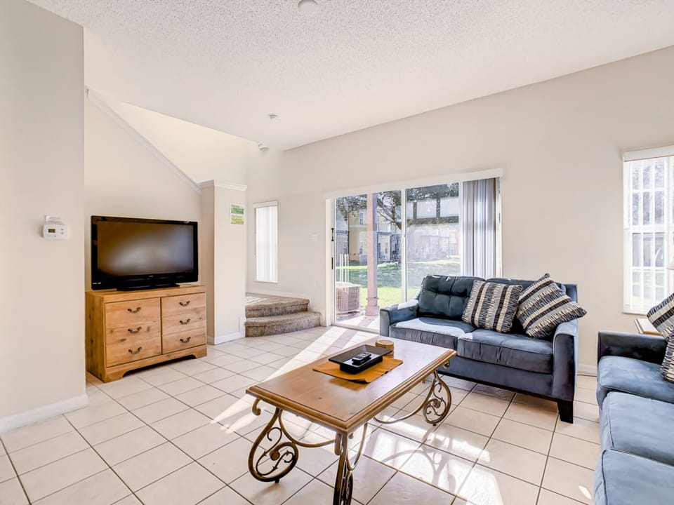 Bright, modern living area with a cozy sofa and a flat-screen TV.