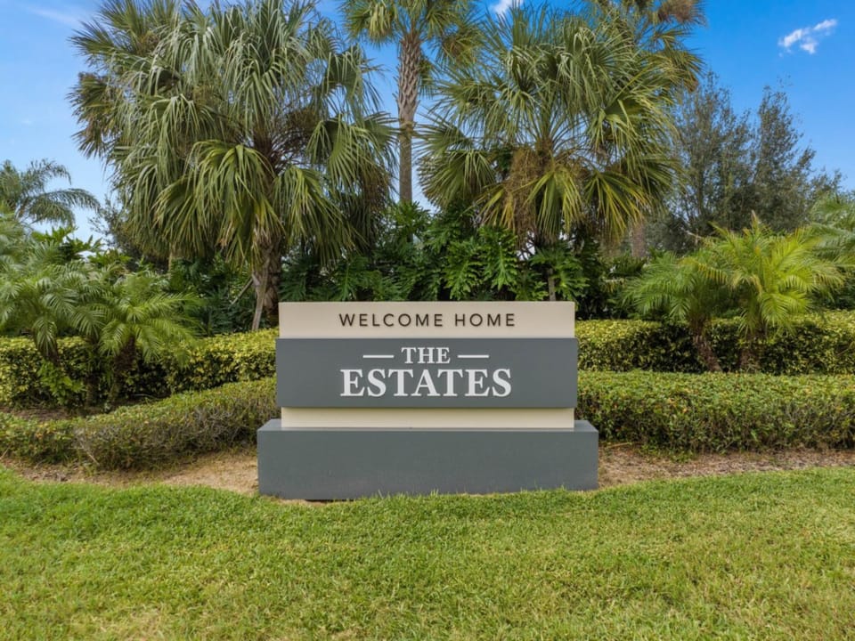 Welcoming entrance to "The Estates" community, surrounded by lush greenery.