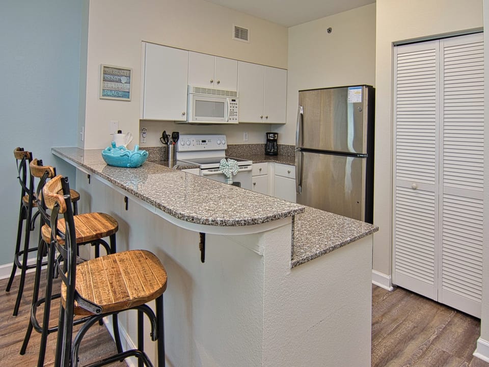Breakfast bar seating for 3 looking into full kitchen
