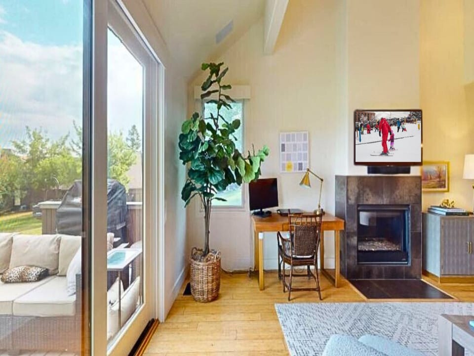 Cozy living room offers plush seating, 50” smart TV, gas fireplace, work desk, access to a private deck