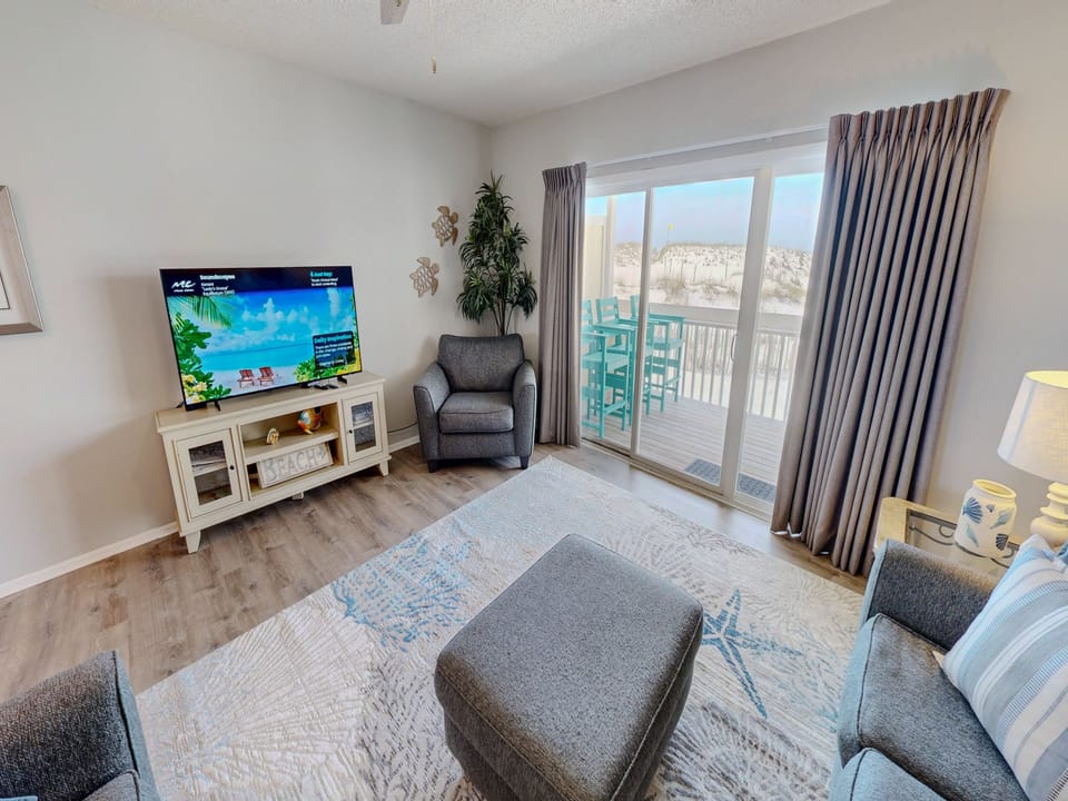Unwind in your living room with coastal views, where soft seating and modern entertainment set the stage for your perfect beach getaway.