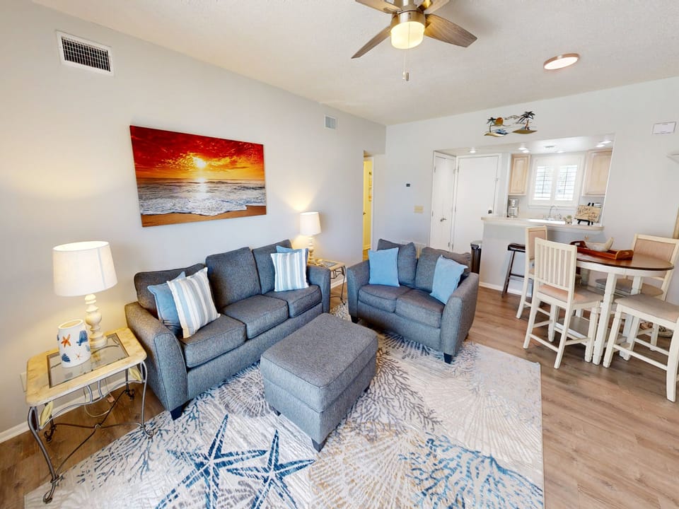 Unwind in this bright, open living space featuring comfortable seating, coastal décor, and a breezy layout that flows effortlessly from the lounge to your fully equipped kitchen.