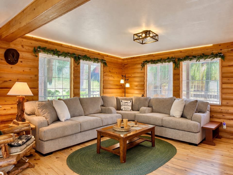 Sink into this spacious sectional surrounded by warm log walls and natural light streaming through large windows for your mountain getaway.