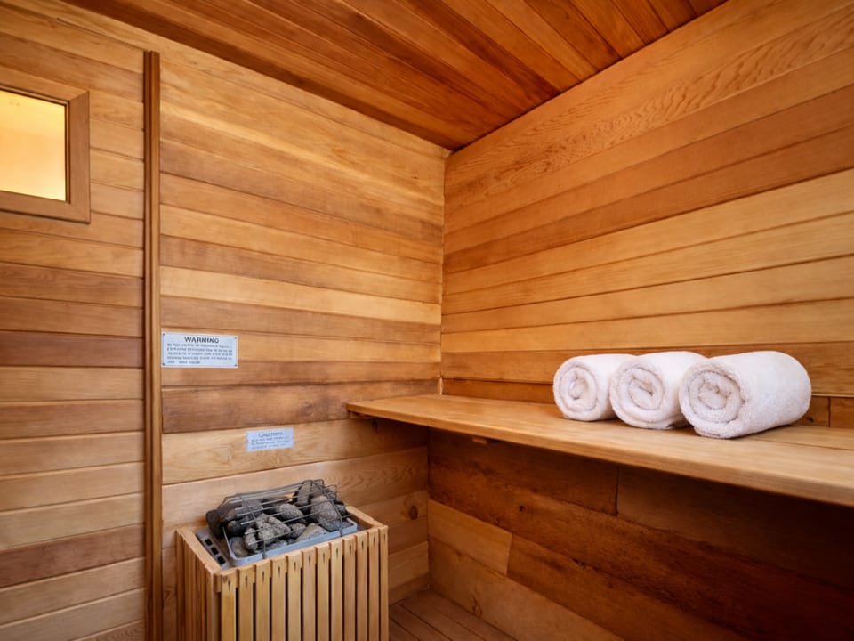 Step into your private wooden sauna, where warm cedar walls and soft towels await your ultimate relaxation experience.