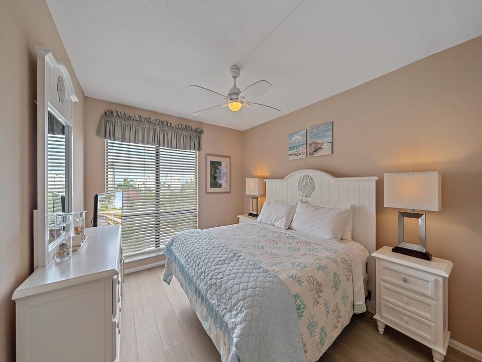Spacious primary bedroom with King sized bed, large window with view, opens up to bathroom and large vanity space.