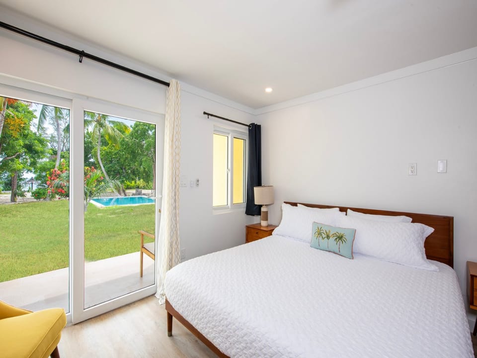 Studio king size bed with porch access and pool views.
