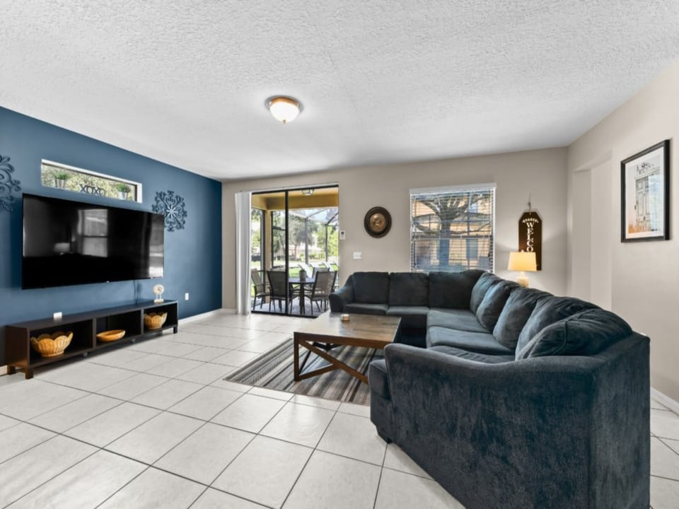 LEISURE ROOM:  Living Room Area with 75” Flat-Screen TV, Sofa with Seating for 5 to 6 people and Direct Access to Patio