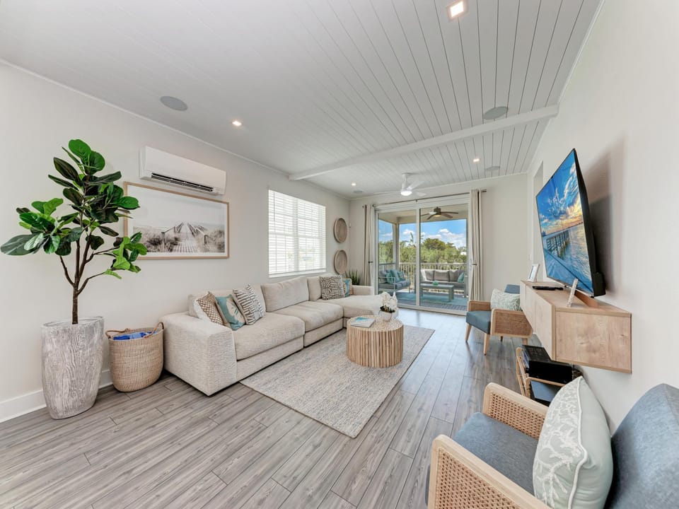 Cozy living room with sliders leading to screened in balcony