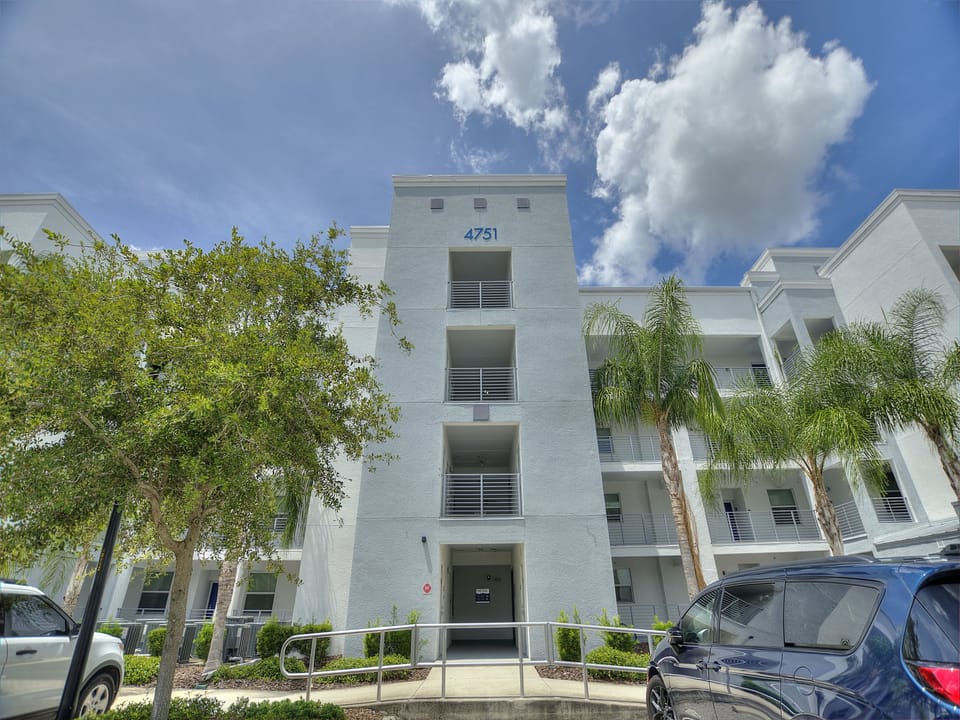 Exterior view of modern Storey Lake condo building surrounded by palm trees – Shine Villas | Sunset Retreat, Storey Lake Resort, Orlando