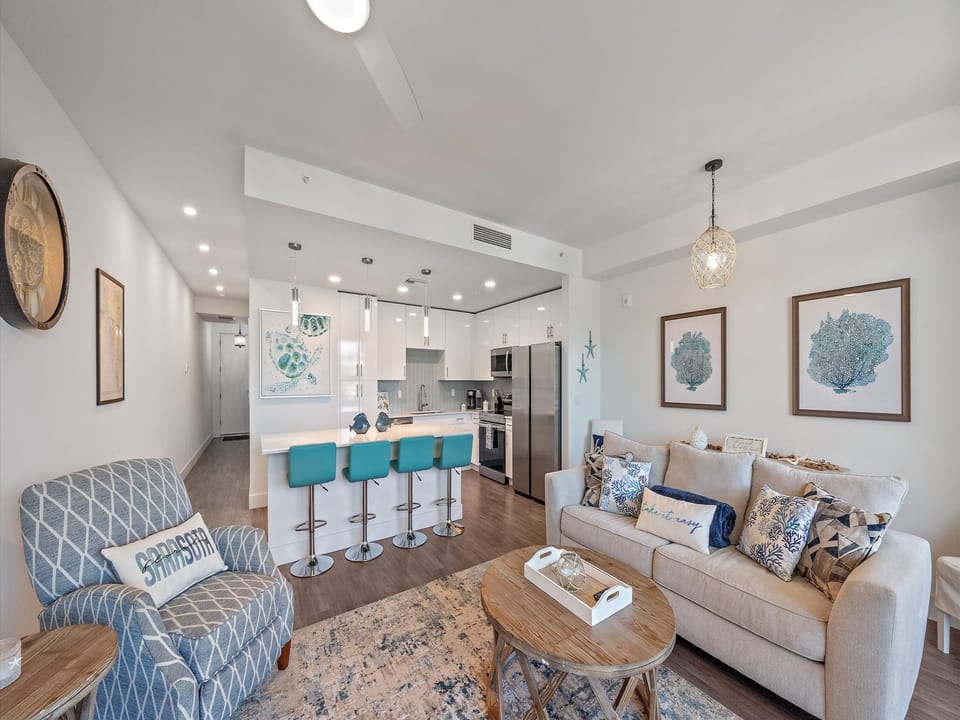 This expansive, open-concept living area is perfectly appointed with coastal decor and offers a beautiful, seamless flow right into the gourmet kitchen.