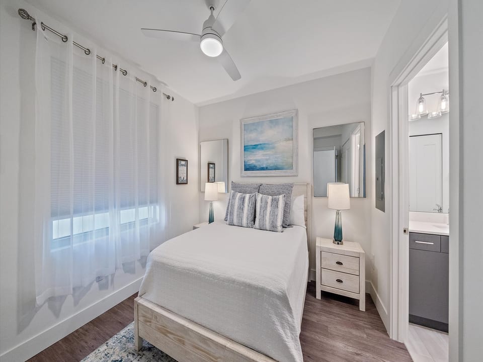 Relax in this serene coastal-inspired bedroom featuring a plush King bed, modern décor, and an en-suite bath for your comfort.
