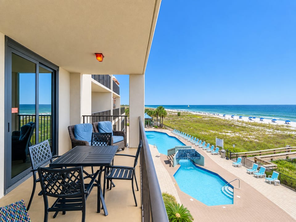 Relax in comfortable seating on the balcony while enjoying views of the pool and the beach beyond