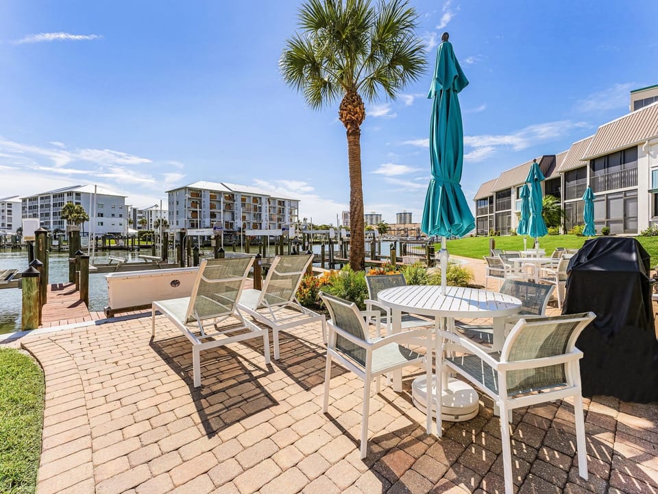 Canal Front Patio with Loungers, Tables, Umbrellas, and a Grill