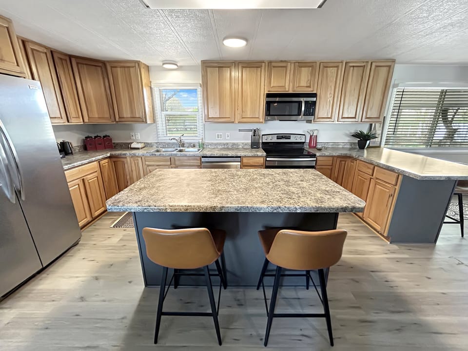 Spacious kitchen with full refrigerator, stove, and dishwasher. Perfect for cooking and hosting big parties.