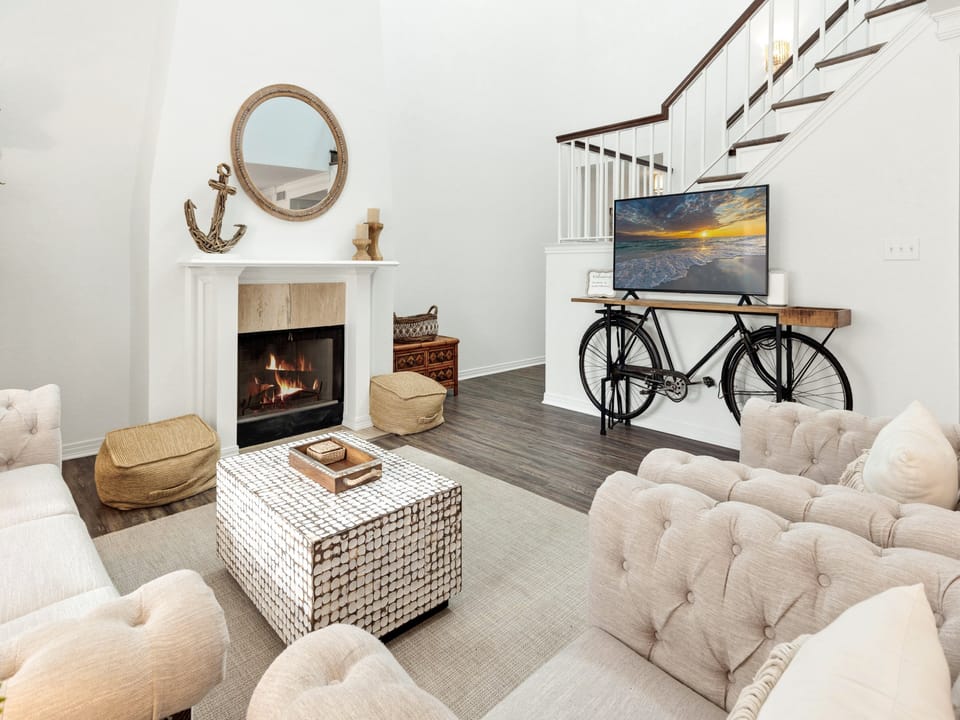 Cozy up by your crackling fireplace in this stylishly furnished living room, complete with plush seating and modern entertainment setup.