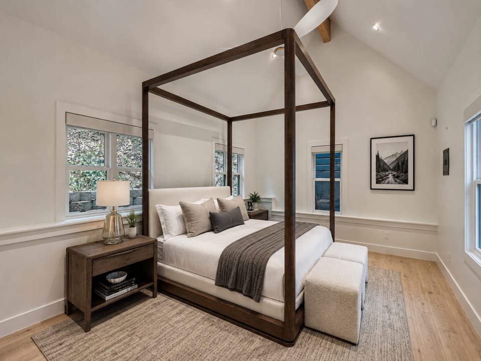 Drift off to sleep beneath the elegant canopy frame, surrounded by soft linens and natural light streaming through multiple windows. Your private retreat awaits.
