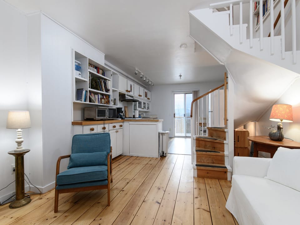 Settle into this two-level retreat with warm hardwood floors, built-in bookshelves, and bright kitchen, perfect for morning coffee.