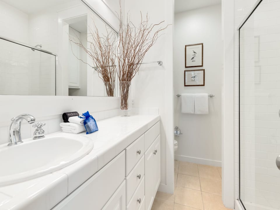 Your pristine bathroom features crisp white marble, plush towels, and elegant touches that create a spa-like sanctuary for your daily routines.