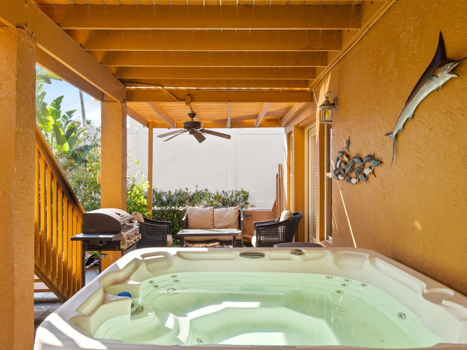 Covered patio featuring a private hot tub and outdoor seating.
