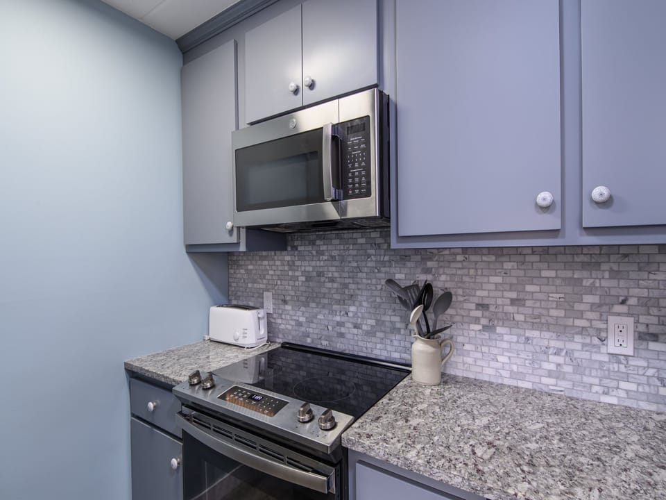 Your fully equipped kitchen features granite countertops, stainless steel appliances, and elegant subway tile backsplash for all your culinary needs.