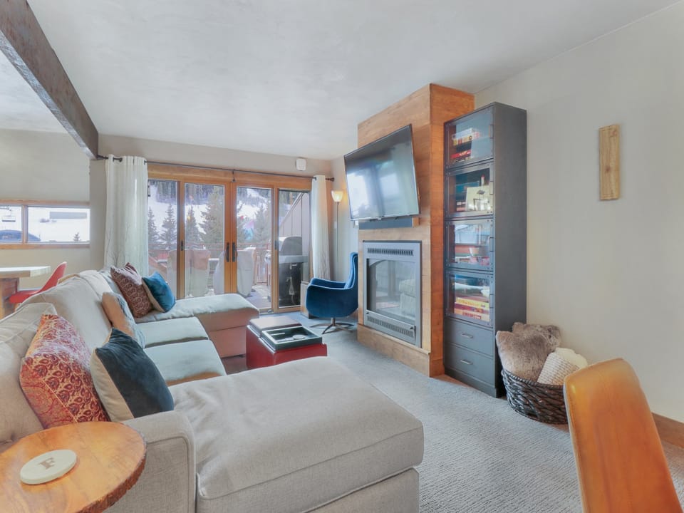 Sink into this cozy living room where modern comfort meets mountain charm. Curl up on the plush sectional by your crackling fireplace while you watch your favorite shows on the wall-mounted TV.
