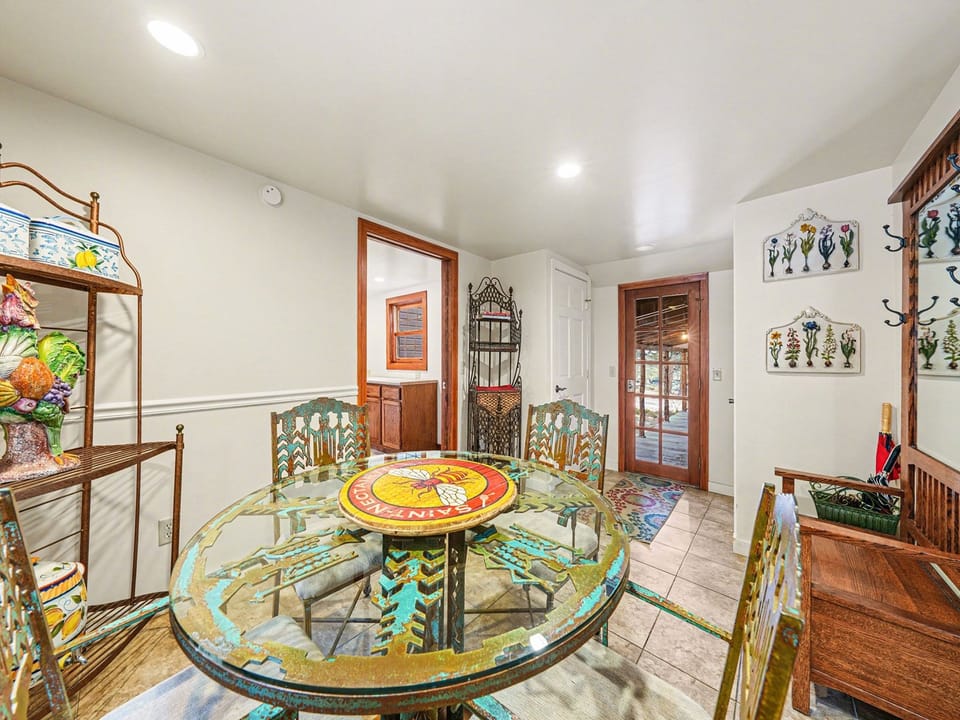 Step into your vibrant dining space where colorful artwork and unique glass table create the perfect setting for memorable meals together.