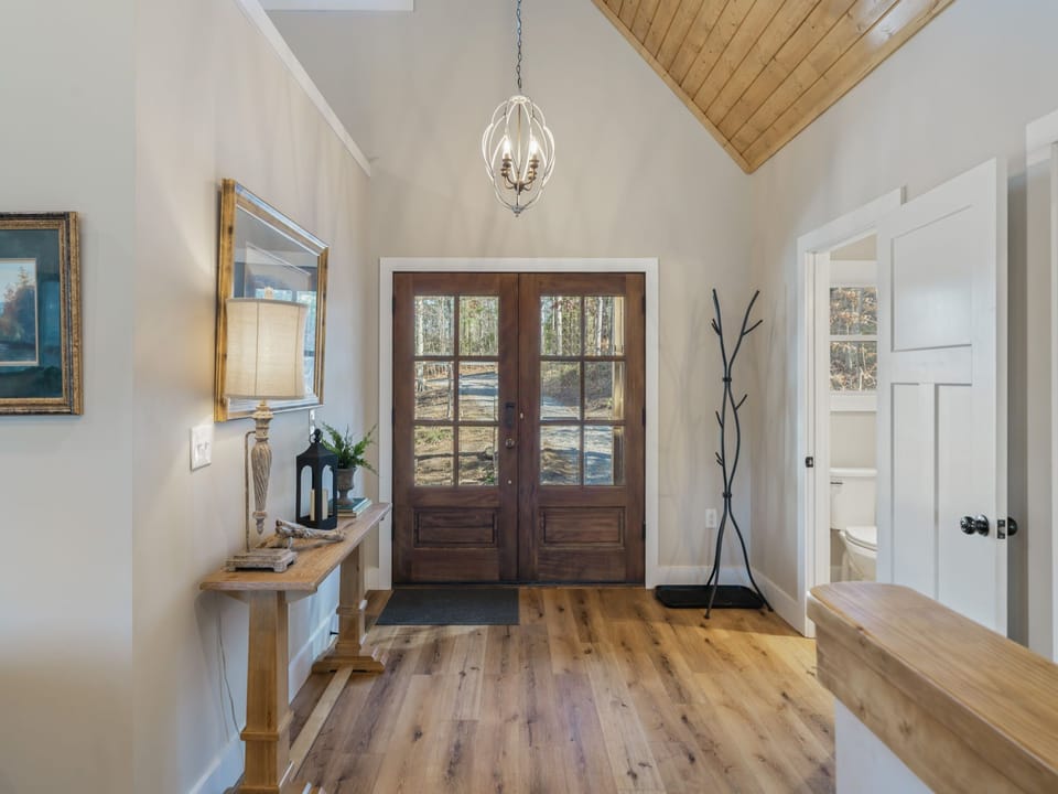 Step into your welcoming entryway with soaring ceilings, warm wood floors, and elegant touches that make this feel like home from the moment you arrive.