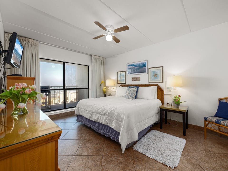 Main bedroom with a king bed and large windows overlooking the beach