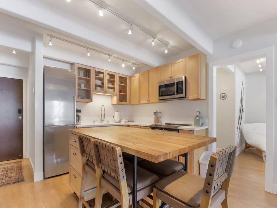 Your open kitchen invites culinary adventures with warm wood cabinetry, sleek stainless appliances, and a spacious island for gathering.