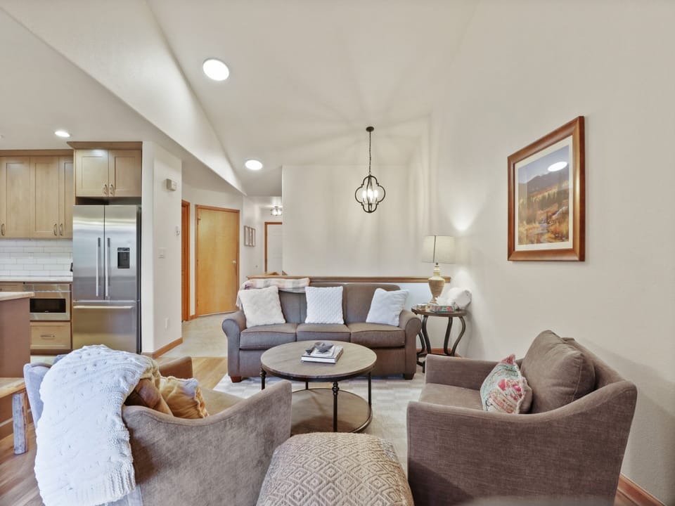 Sink into plush seating where natural light dances across warm wood floors, creating your perfect retreat.
