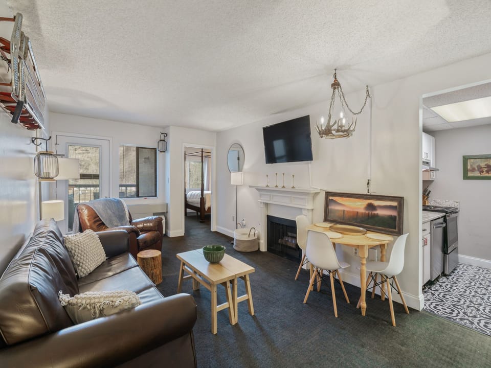 Unwind in your thoughtfully designed living space with cozy leather seating, crackling fireplace, and modern kitchen just steps away.