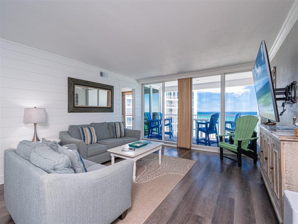 Unwind in your stylish living space with plush seating and stunning ocean views through floor-to-ceiling windows.