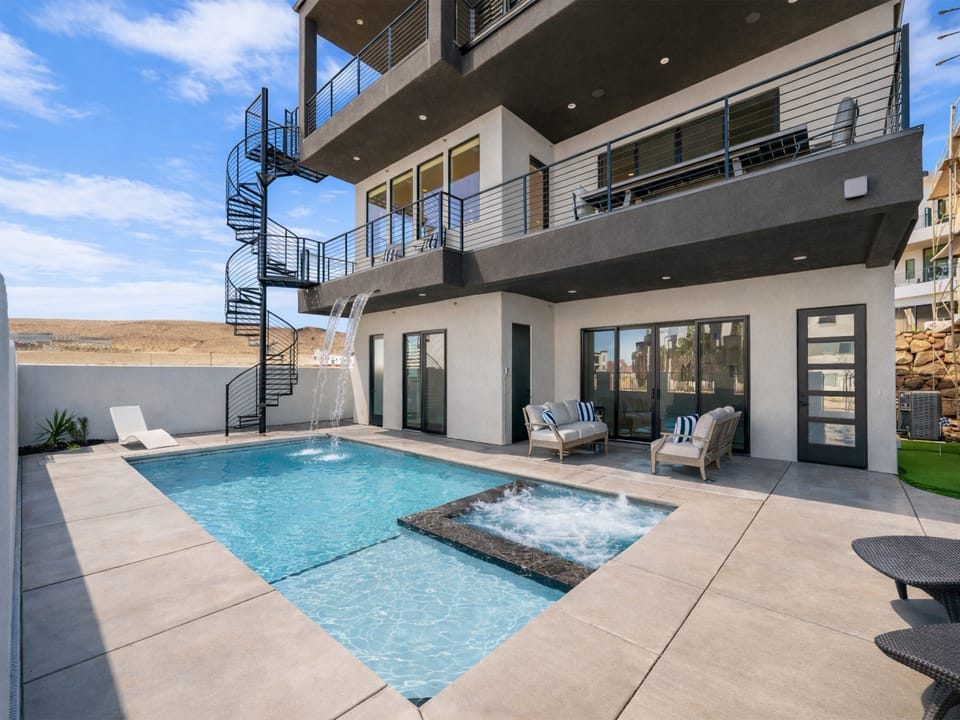 Modern multi-level vacation home with private pool and hot tub, featuring contemporary architecture and mountain desert surroundings.